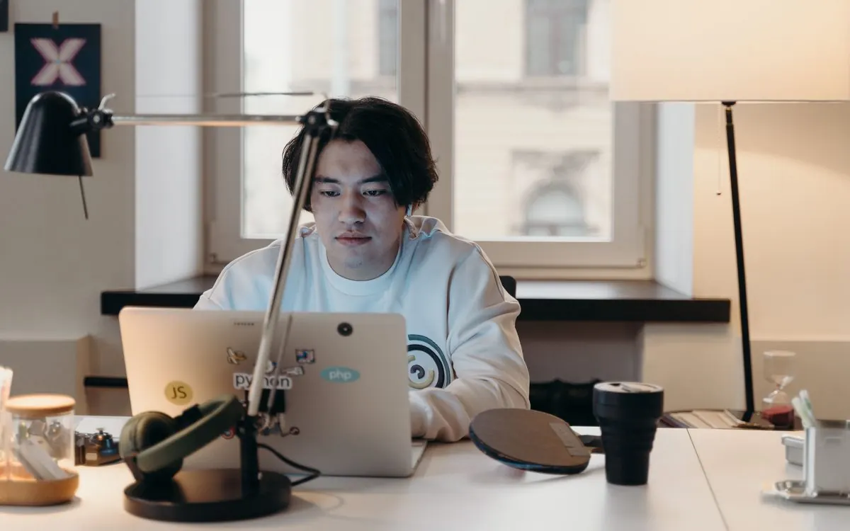 Profissional trabalhando no notebook em um ambiente escuro