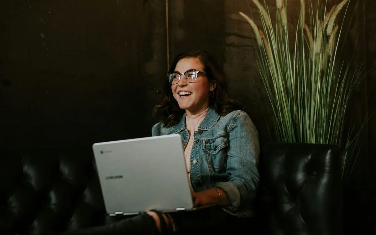 Profissional sorrindo enquanto trabalha no notebook